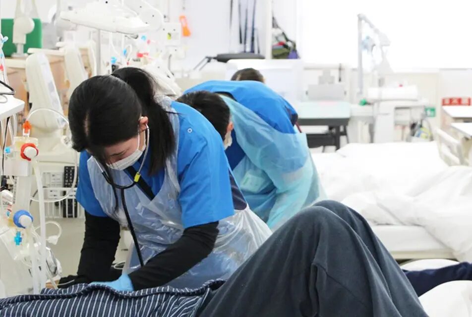 透析治療中の様子。医療スタッフが患者の腕に処置している